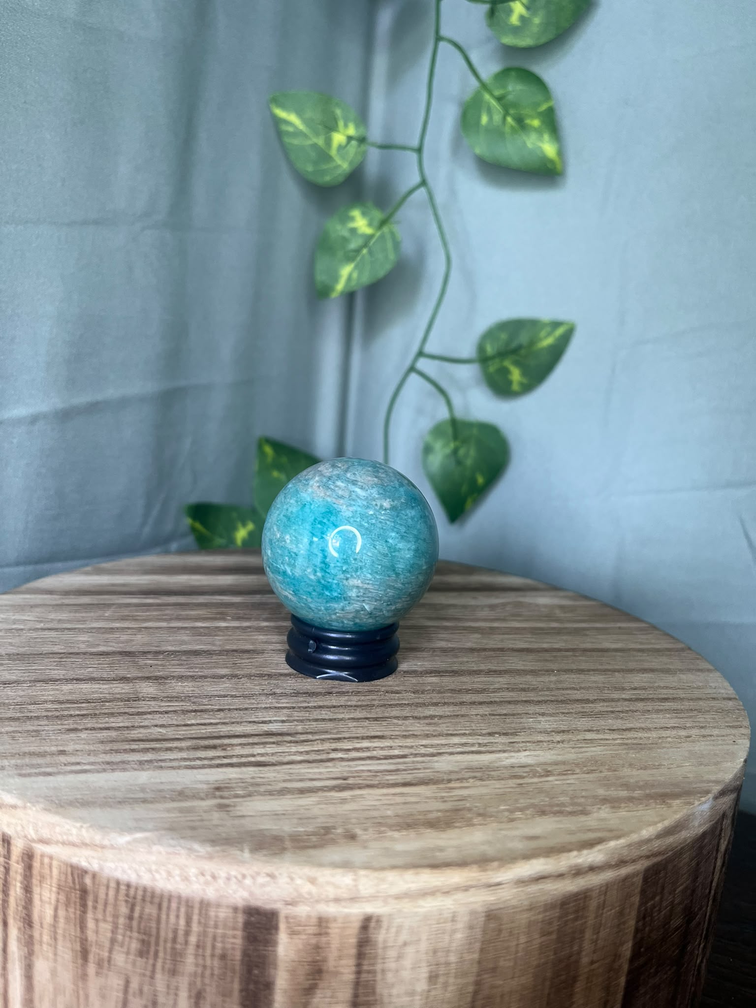 102g natural Amazonite crystal sphere featuring vibrant turquoise-blue colouring with soft white marbling and a polished finish.