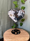 401g natural Moss Agate heart crystal carving on a black metal display stand with green, cream and earthy dendritic inclusions.