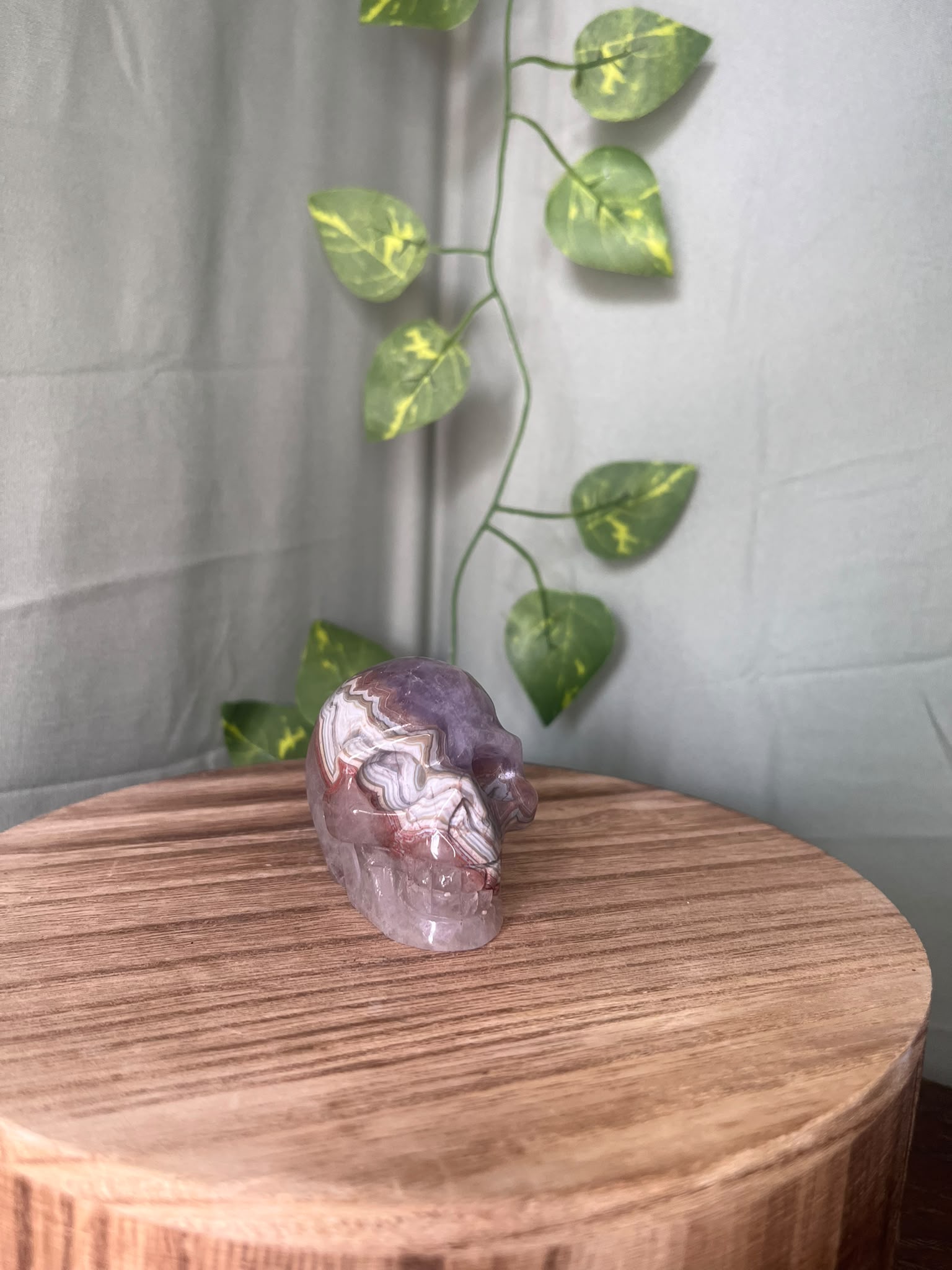 150g natural Amethyst and Agate crystal skull carving featuring intricate lace banding and soft purple quartz tones.