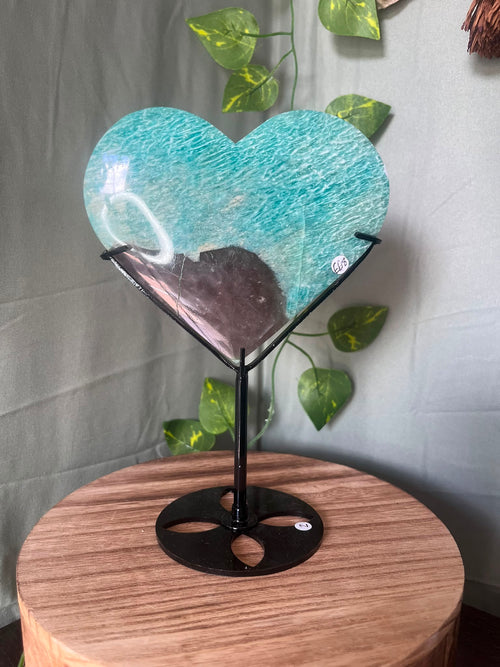 475g natural Amazonite heart crystal with Smoky Quartz matrix displayed on a black metal stand featuring vibrant turquoise-blue colouring.