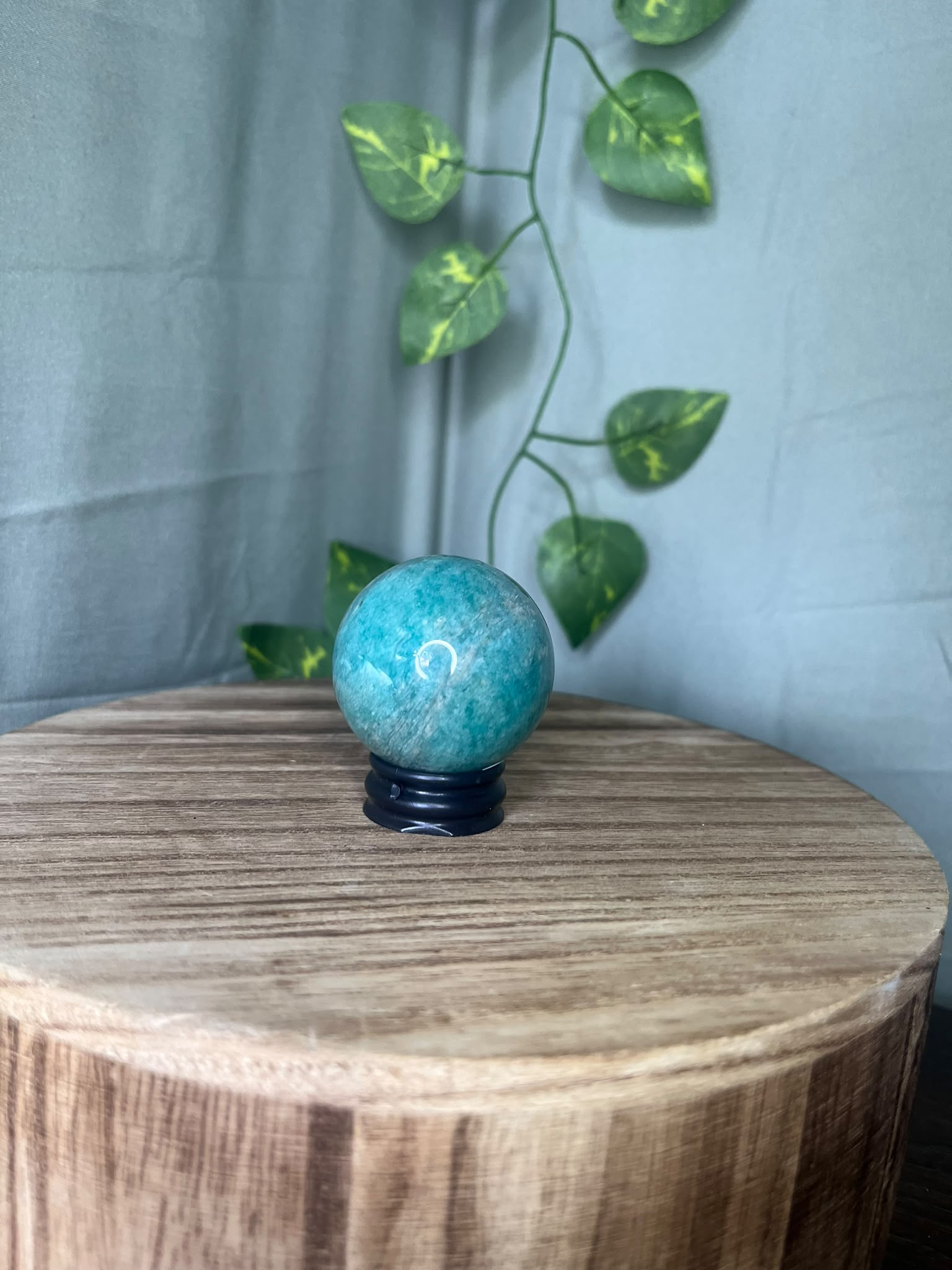 102g natural Amazonite crystal sphere featuring vibrant turquoise-blue colouring with soft white marbling and a polished finish.