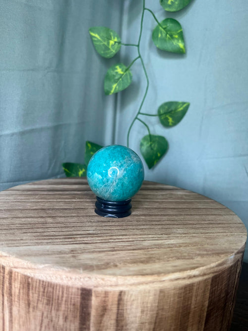 102g natural Amazonite crystal sphere featuring vibrant turquoise-blue colouring with soft white marbling and a polished finish.