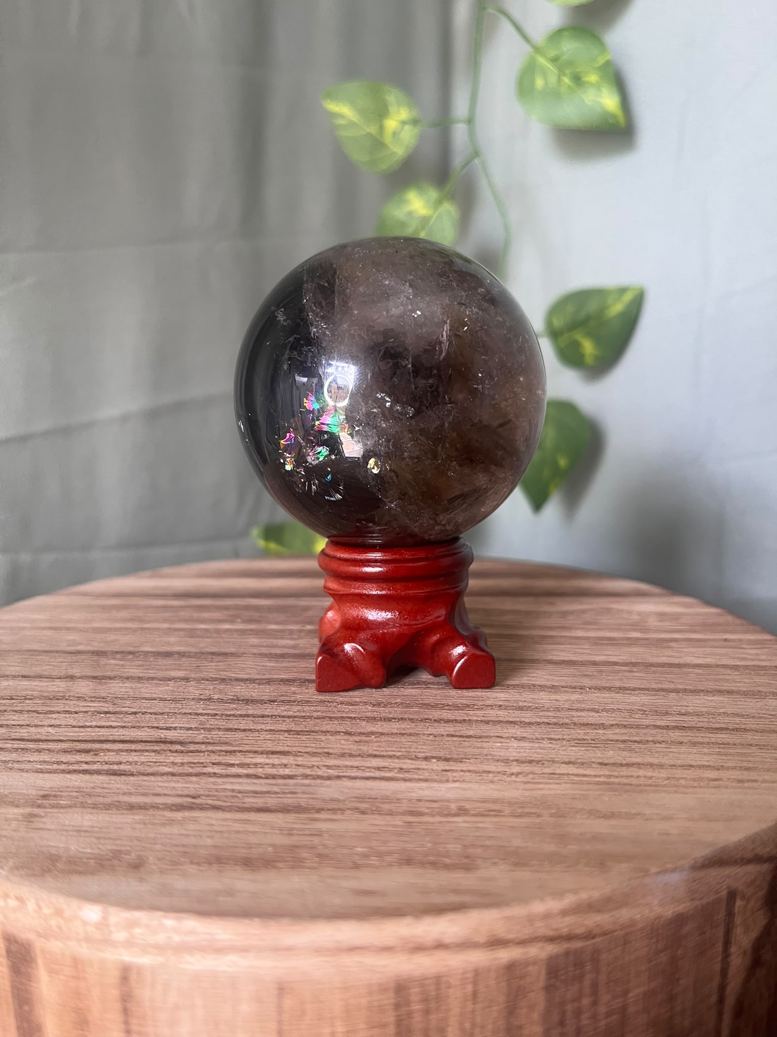339g polished Rainbow Smoky Quartz sphere featuring deep smoky colouring with natural rainbow inclusions and a glossy finish.