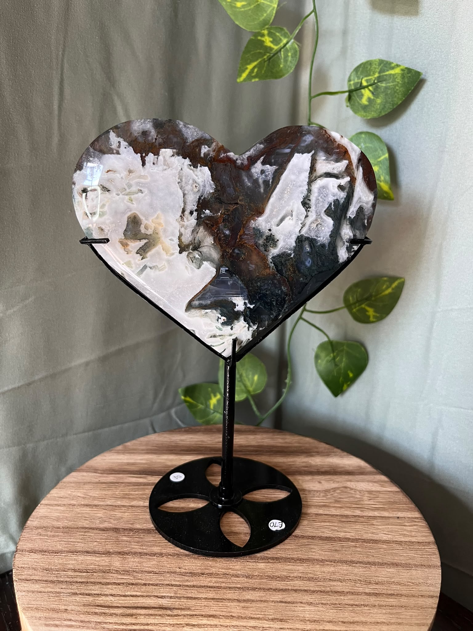 401g natural Moss Agate heart crystal carving on a black metal display stand with green, cream and earthy dendritic inclusions.