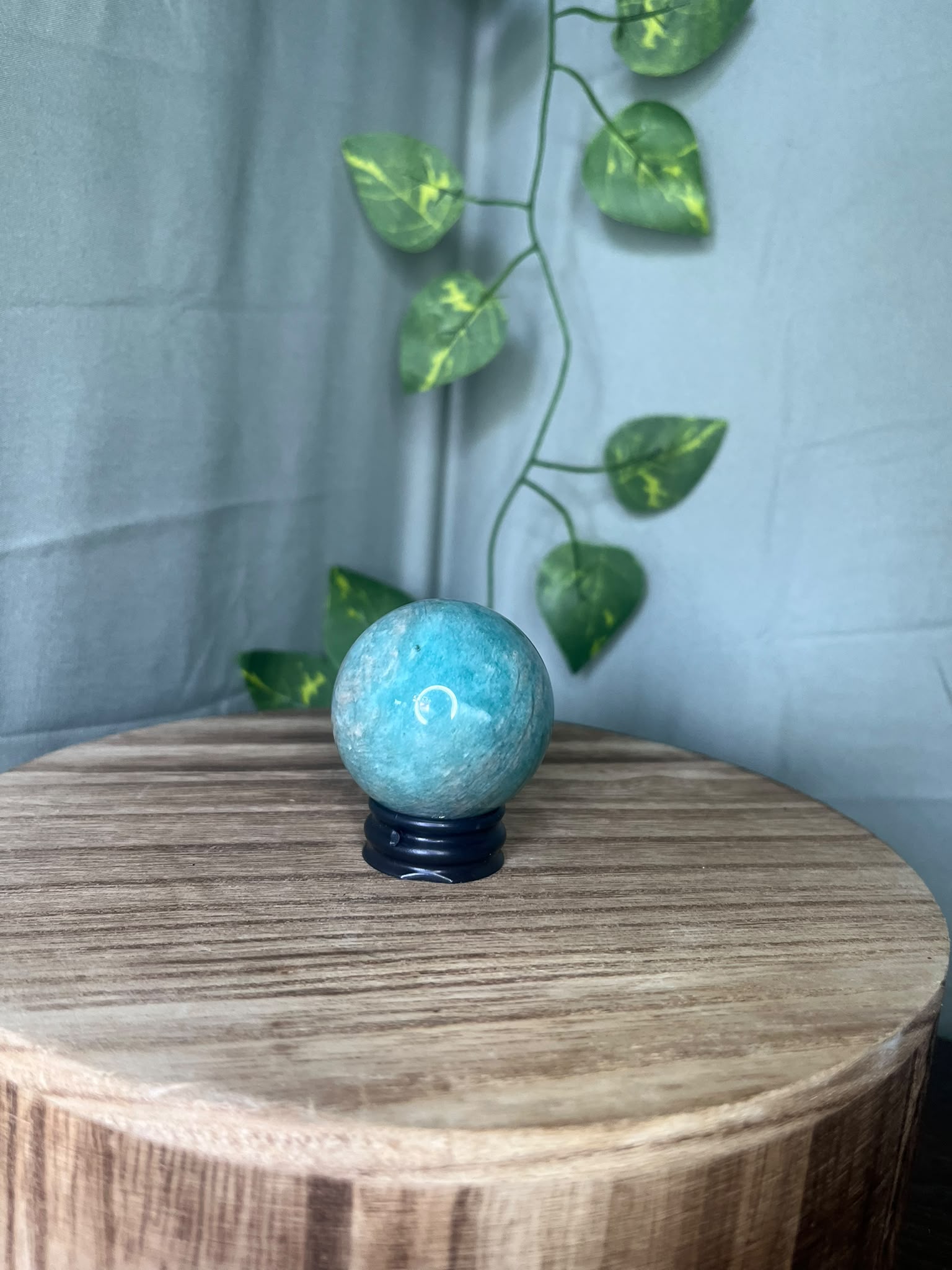 102g natural Amazonite crystal sphere featuring vibrant turquoise-blue colouring with soft white marbling and a polished finish.