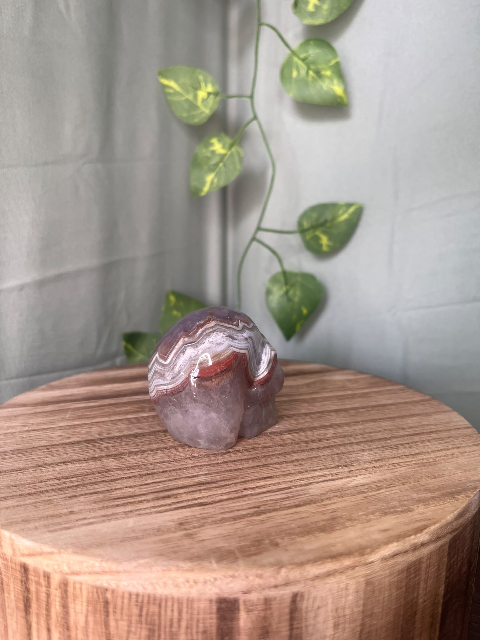 150g natural Amethyst and Agate crystal skull carving featuring intricate lace banding and soft purple quartz tones.