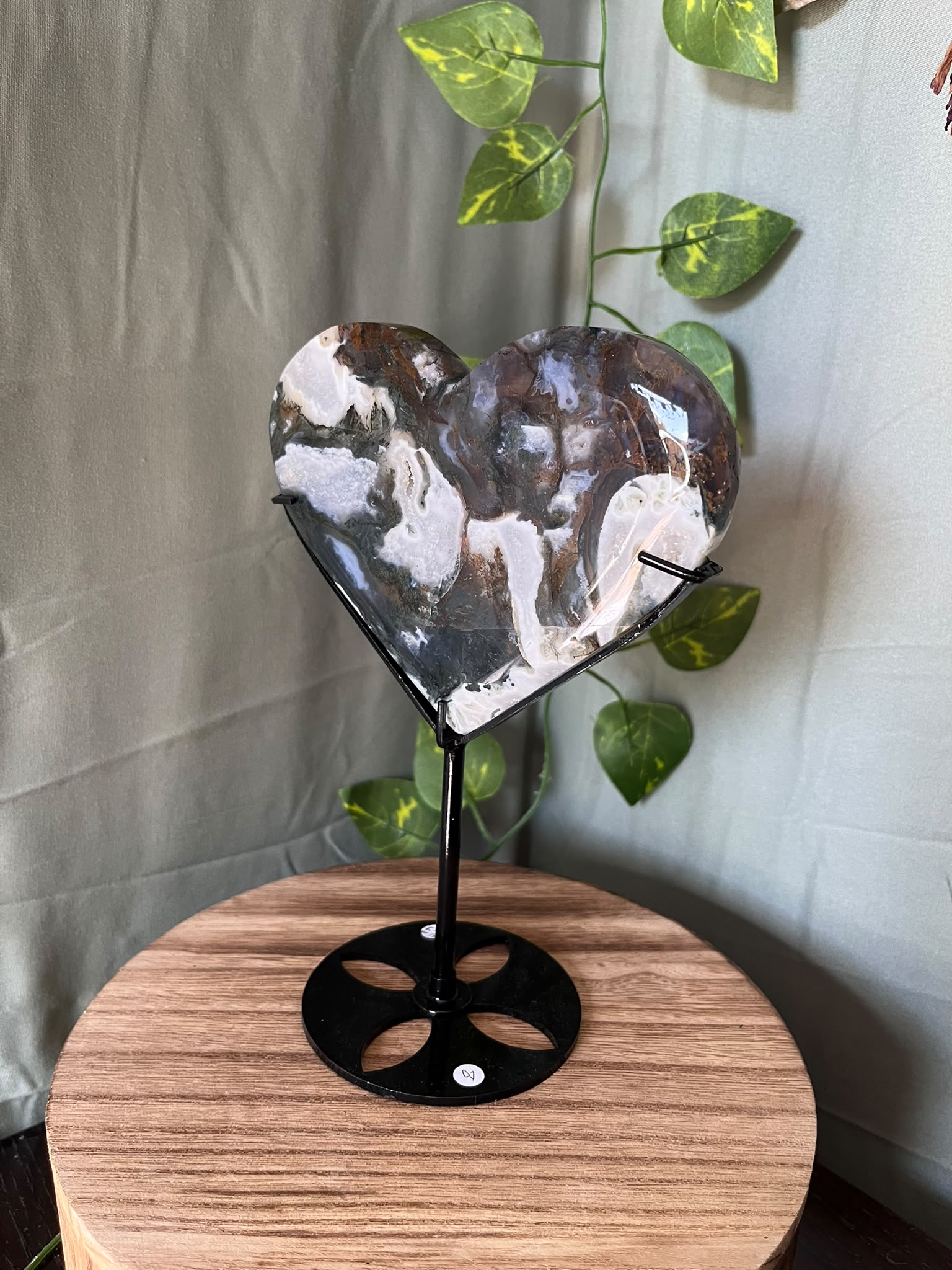 401g natural Moss Agate heart crystal carving on a black metal display stand with green, cream and earthy dendritic inclusions.
