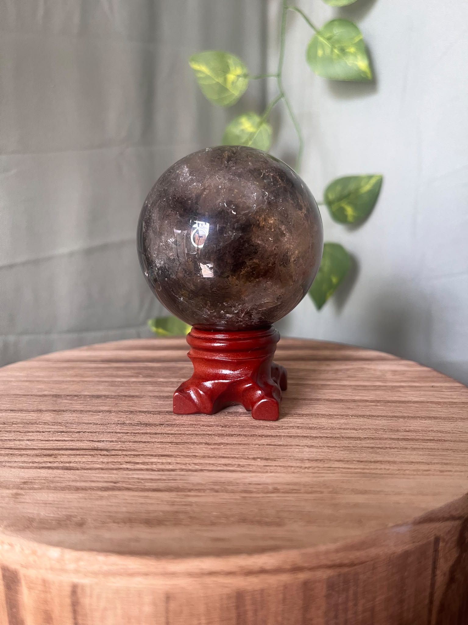 339g polished Rainbow Smoky Quartz sphere featuring deep smoky colouring with natural rainbow inclusions and a glossy finish.