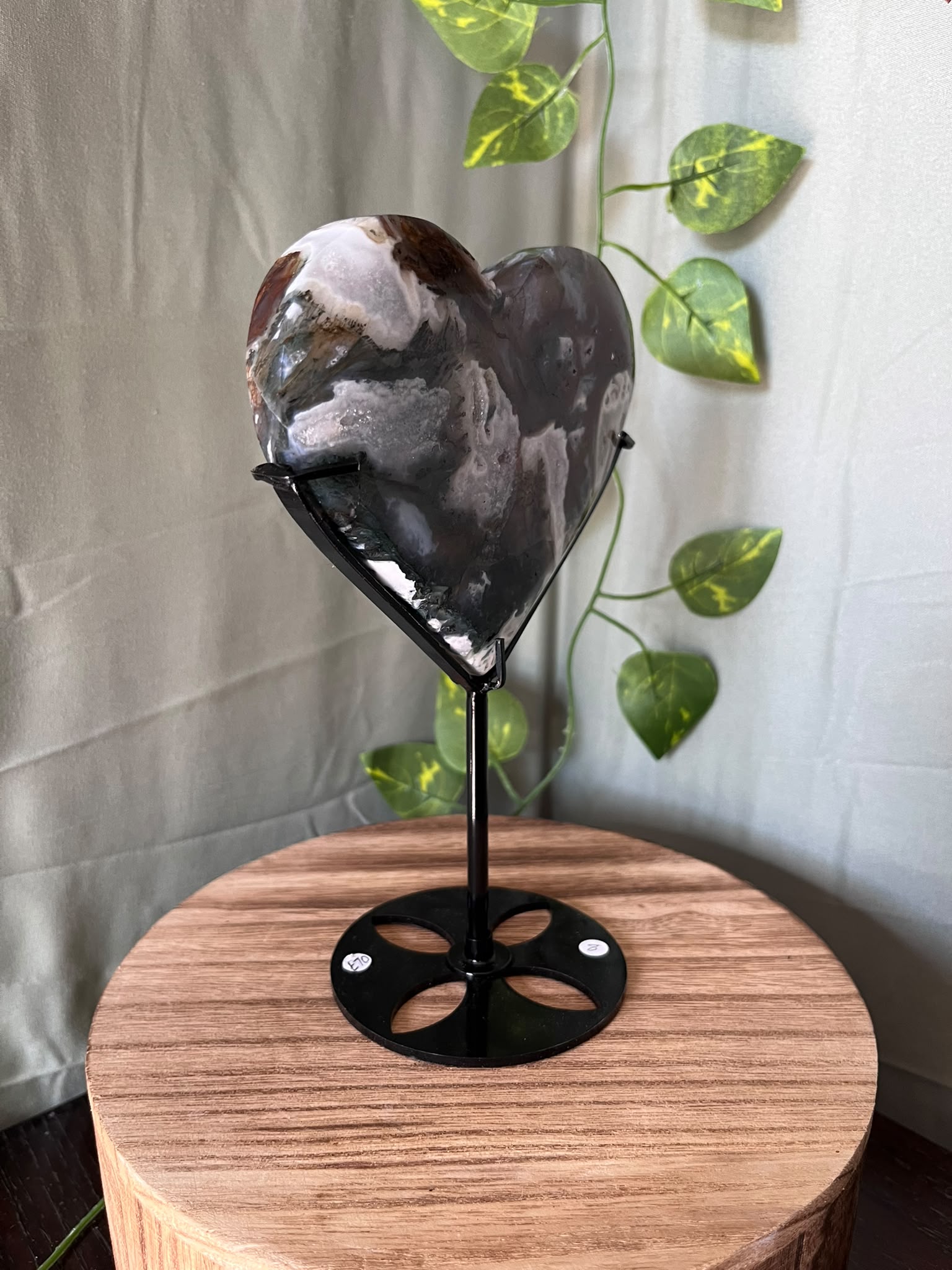 401g natural Moss Agate heart crystal carving on a black metal display stand with green, cream and earthy dendritic inclusions.