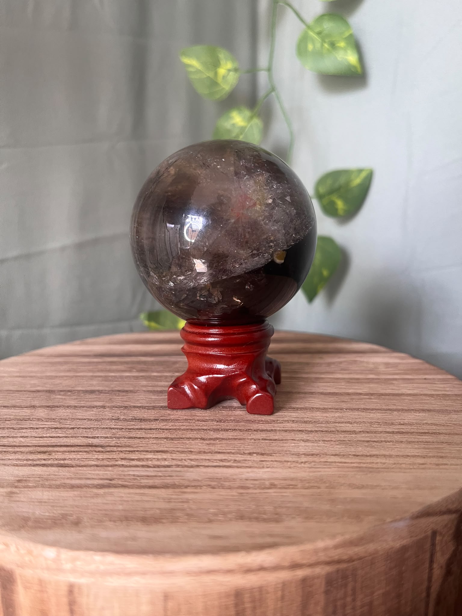 339g polished Rainbow Smoky Quartz sphere featuring deep smoky colouring with natural rainbow inclusions and a glossy finish.