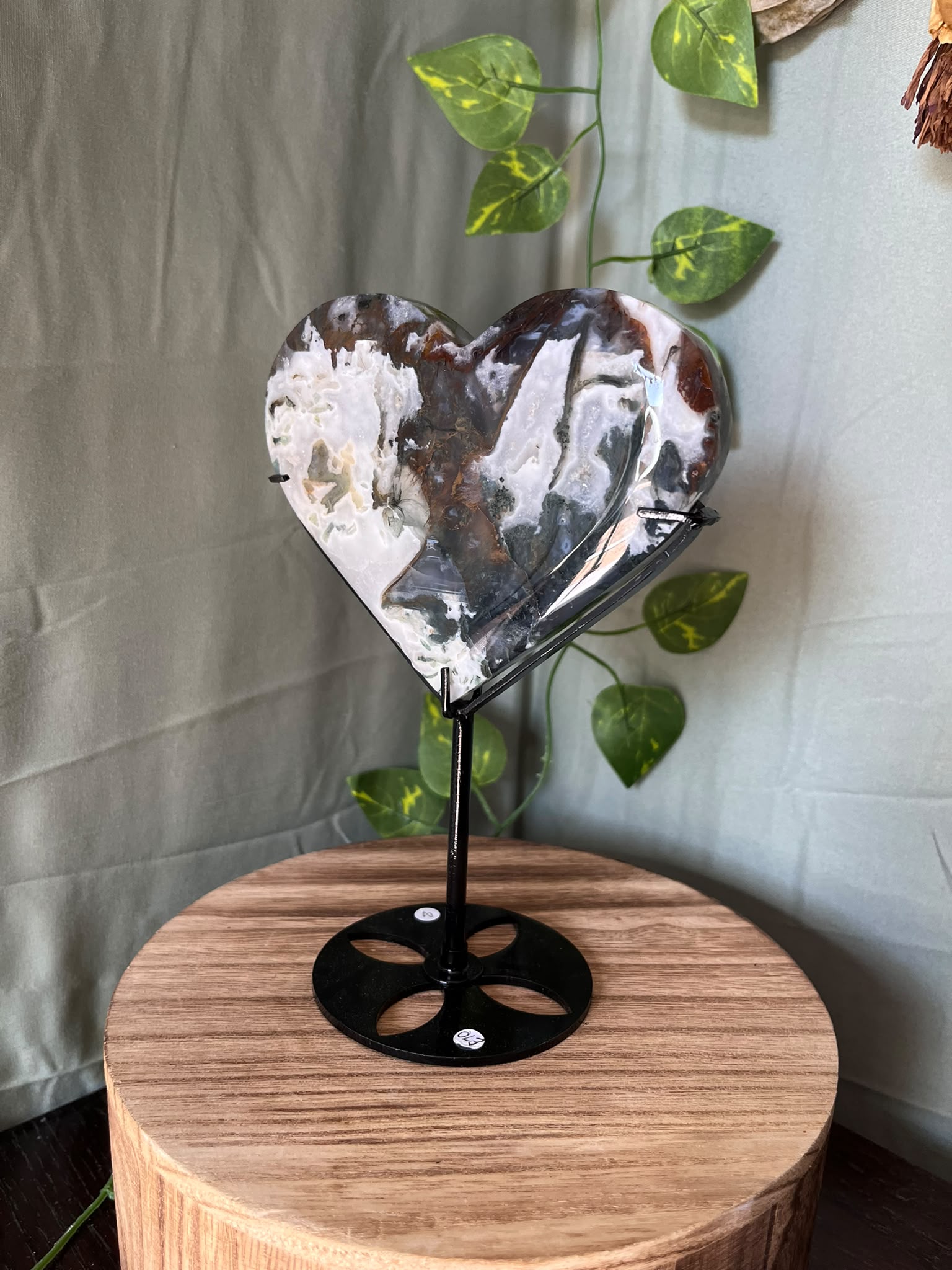 401g natural Moss Agate heart crystal carving on a black metal display stand with green, cream and earthy dendritic inclusions.