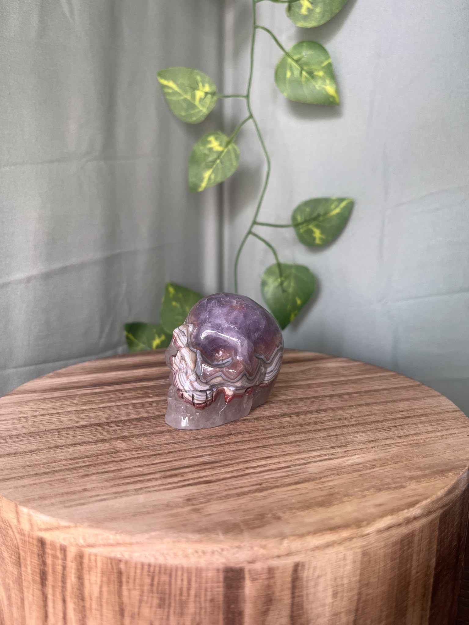150g natural Amethyst and Agate crystal skull carving featuring intricate lace banding and soft purple quartz tones.