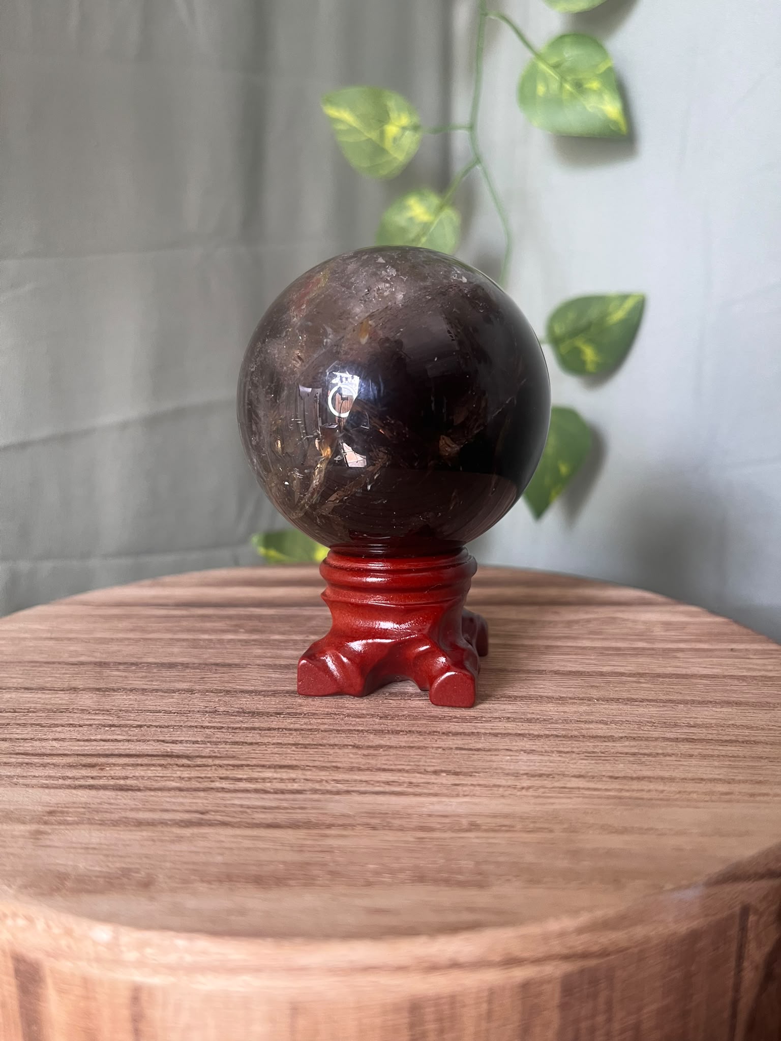 339g polished Rainbow Smoky Quartz sphere featuring deep smoky colouring with natural rainbow inclusions and a glossy finish.
