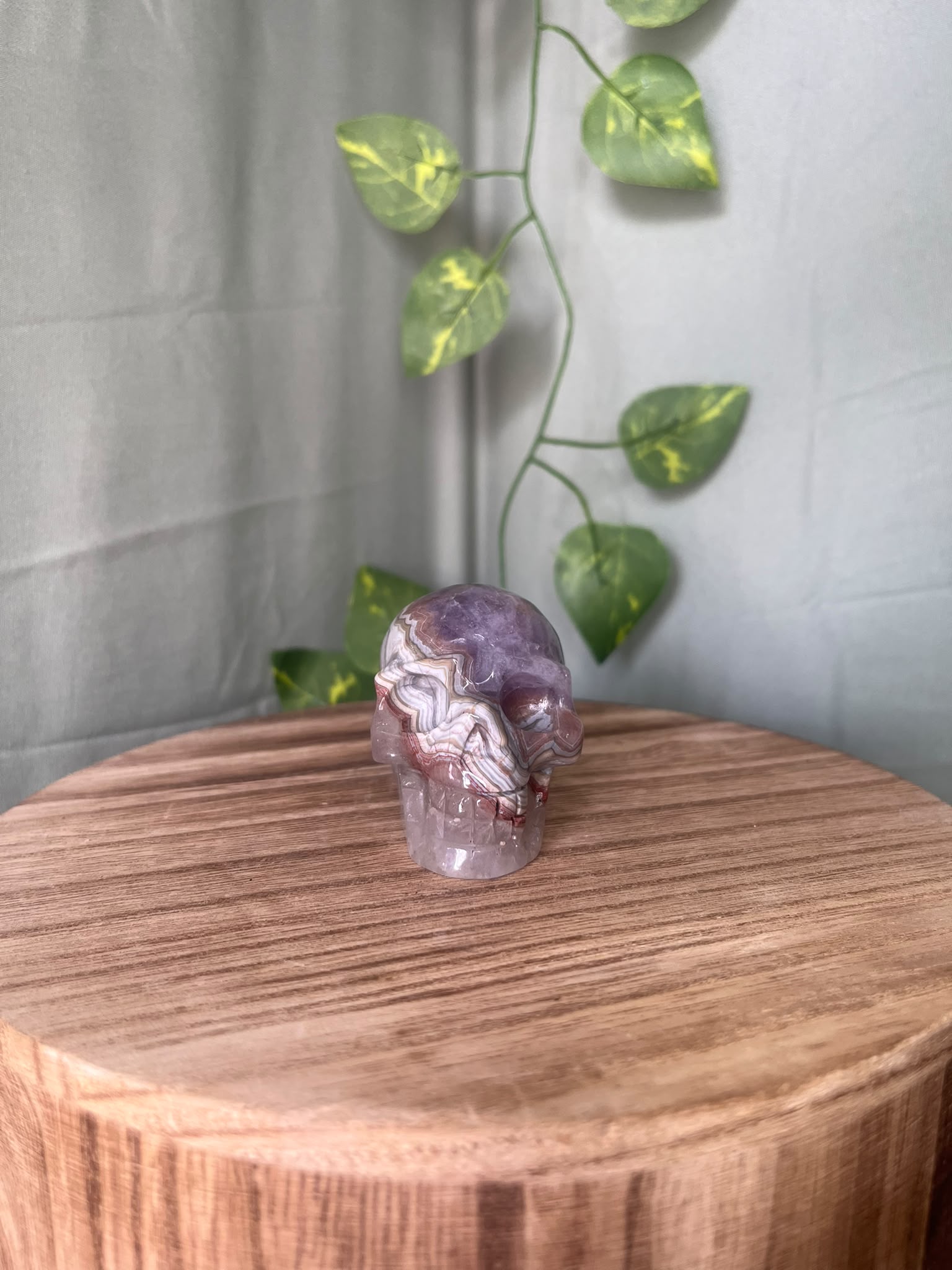 150g natural Amethyst and Agate crystal skull carving featuring intricate lace banding and soft purple quartz tones.